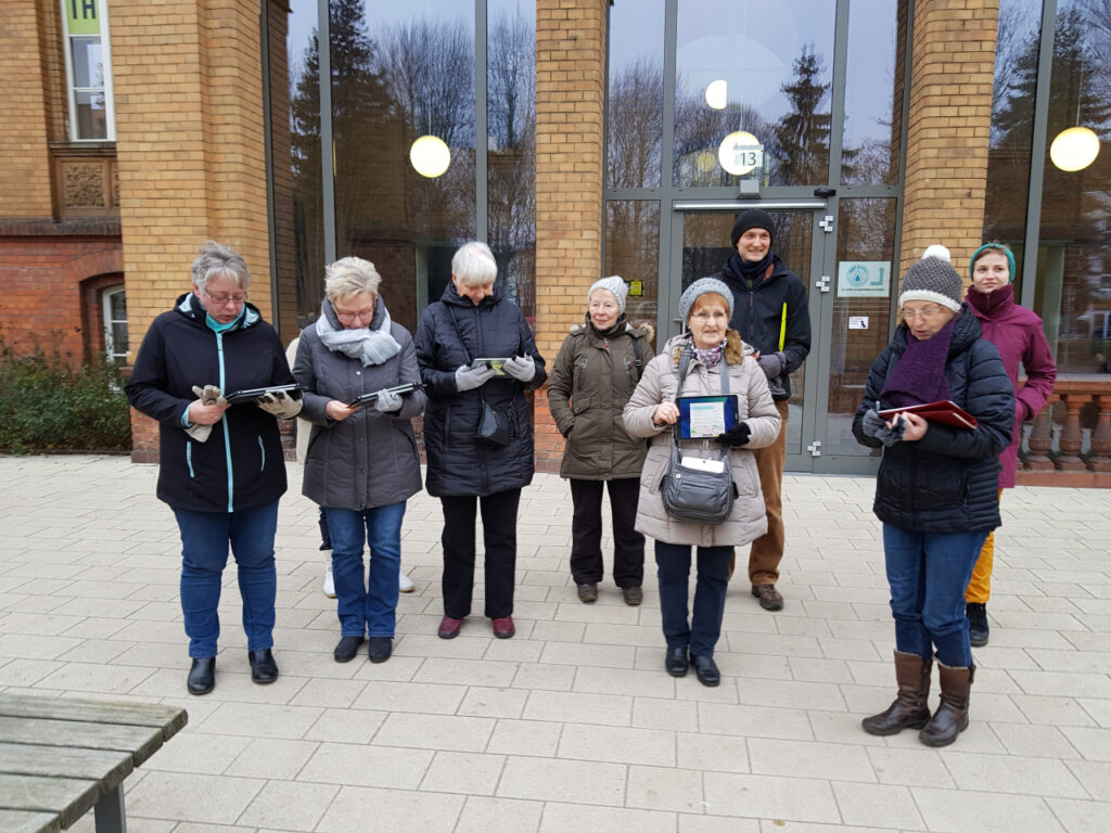 Eine Gruppe älterer Menschen. Alle halten ein Tablet vor sich.