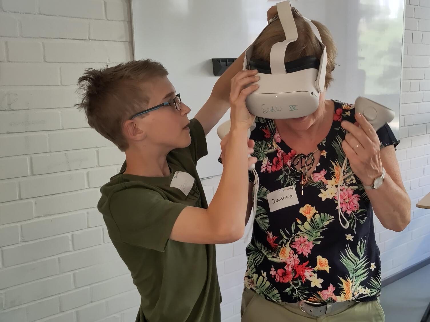 Junge unterstützt Ältere beim Aufsetzen einer VR-Brille