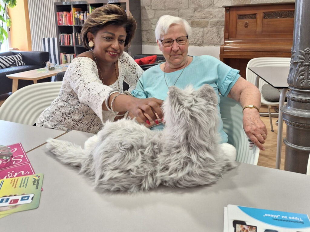 Zwei Frauen schauen auf eine Roboterkatze