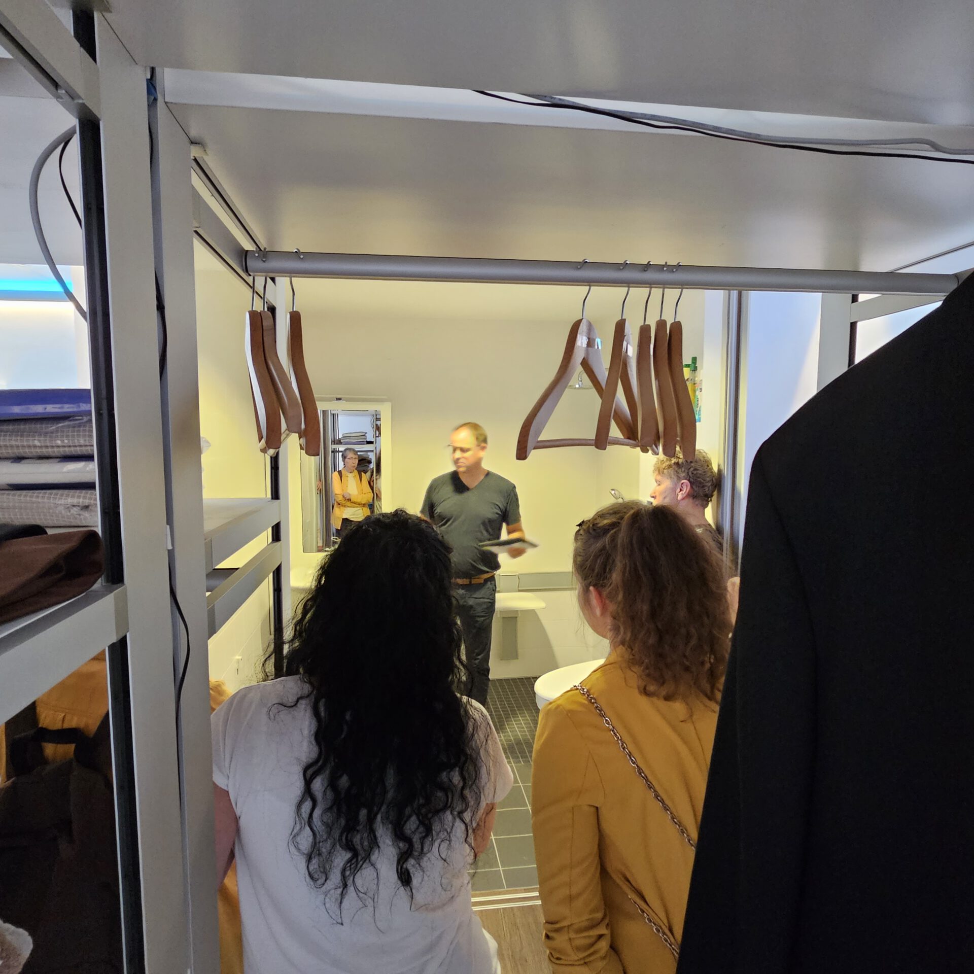 Blick durch einen Kleiderschrank aufs Badezimmer