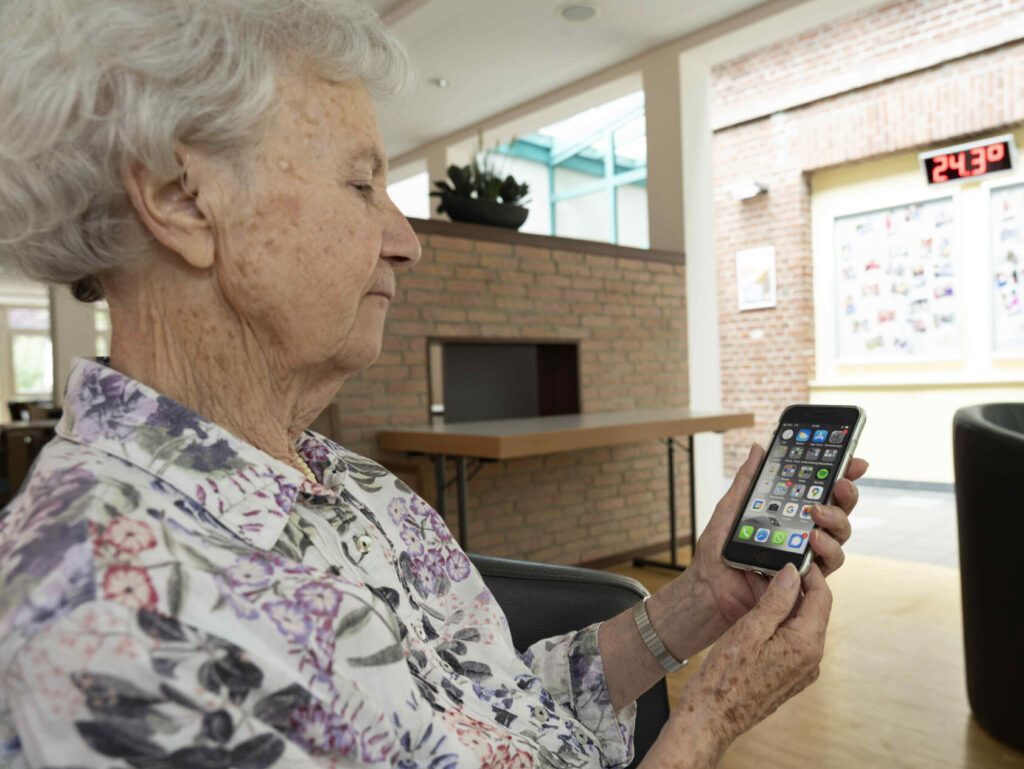 Ältere Frau schaut auf Smartphone