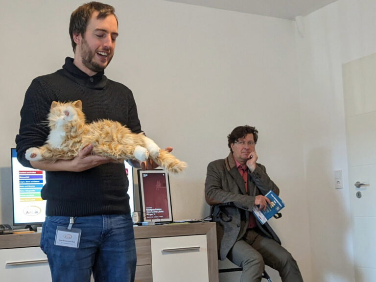 Ein Mann präsentiert eine Roboterkatze