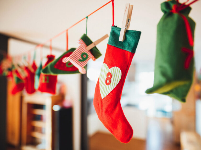 Detailaufnahme eines Adventskalenders aus einer Schnur und kleinen Päckchen, die daran hängen