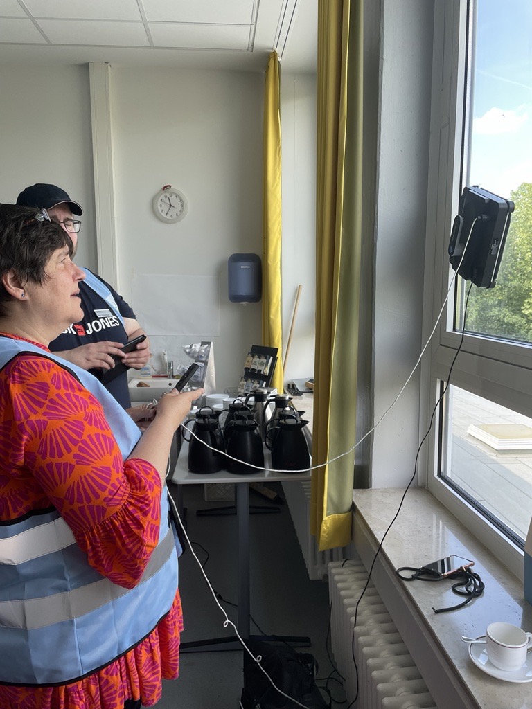 eine Frau und ein Mann probieren einen Fensterputzroboter aus