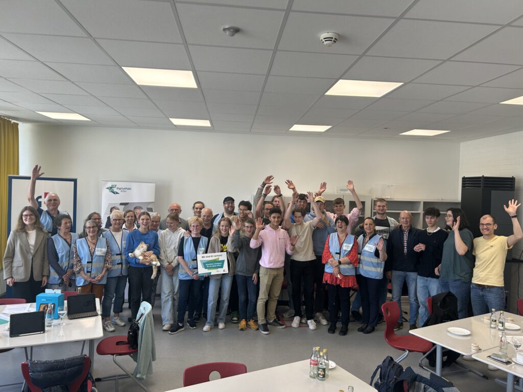 Gruppenbild mit mehreren älteren Menschen und Schülerinnen und Schülern