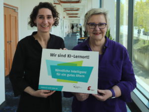 Cosima Ingenschay Stellvertretende Vorsitzende der EVG und Engagierte halten ein Schild auf dem wir sind KI-Lernort, KI für ein gutes Altern steht