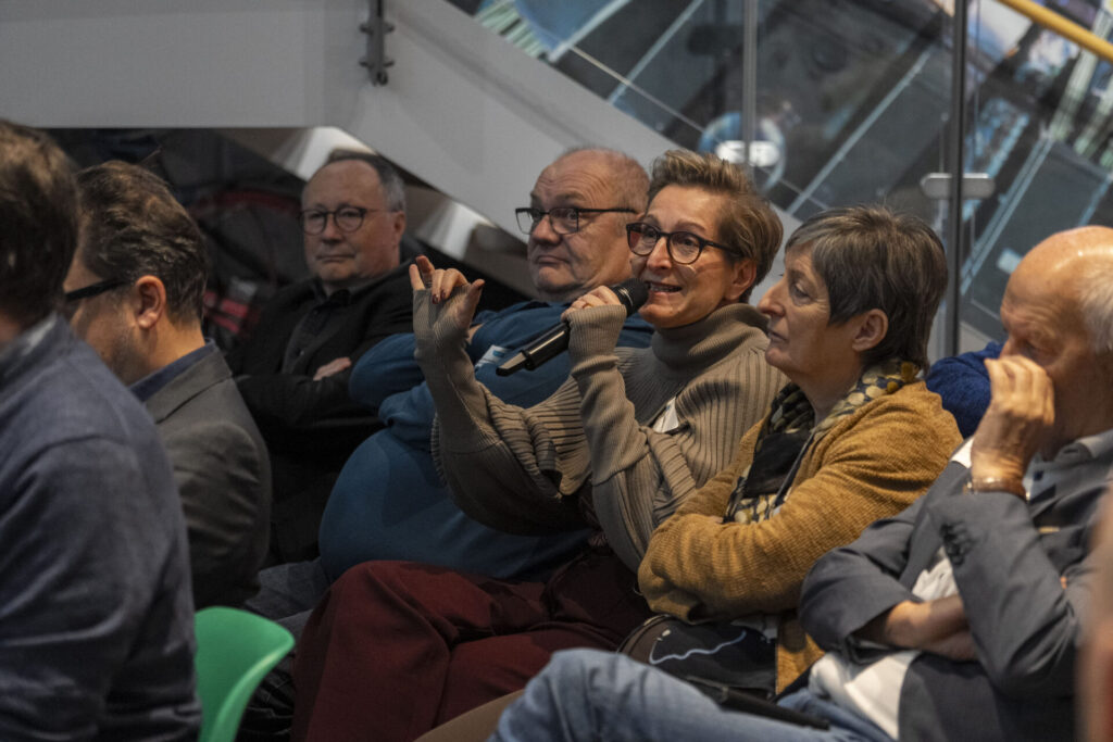 Frau die im Publikum eine Frage stellt