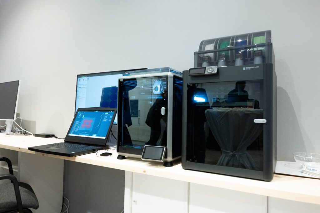 ein 3-D-Drucker steht neben einem Laptop